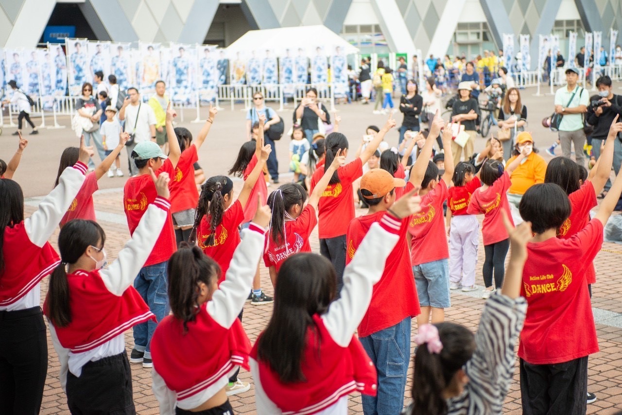 屋外イベントで踊るダンスの子どもたち